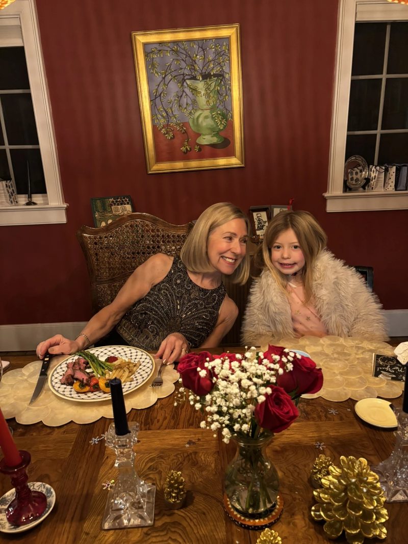 Grandmother and her granddaughter side by side at a candlelit dinner