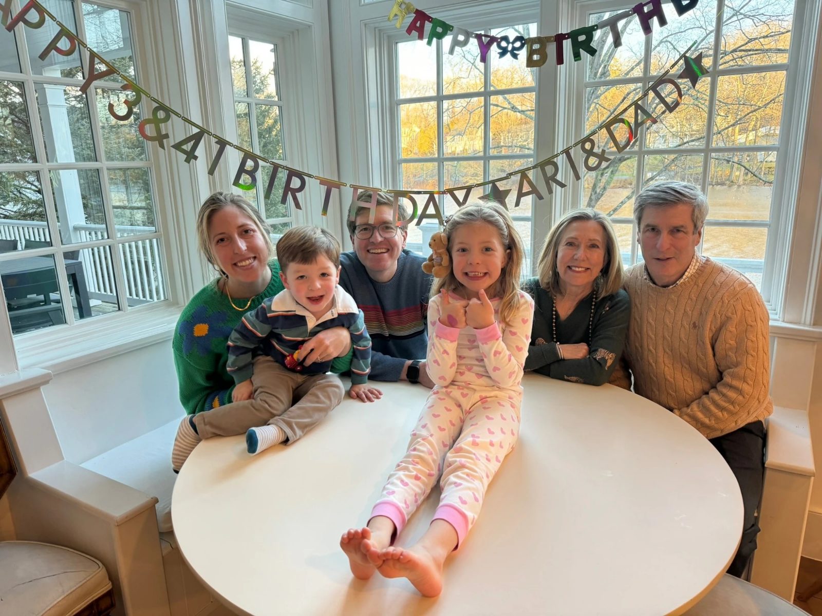 The whole family gathered together under a Happy Birthday banner